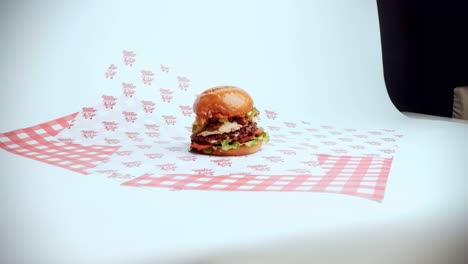 4k cinematic food footage of a delicious homemade burger displayed in a restaurant on a white background with studio lighting