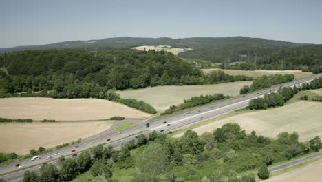 Vista-Aérea-De-Drones-De-Autos-Que-Viajan-En-La-Autopista-Alemana-Bajo-La-Dura-Luz-Del-Sol,-Alemania,-Europa