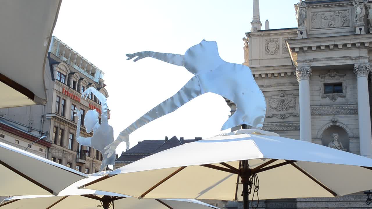 Ballerinaer på parasollerne ved Lviv café. Lvivs opera- og balletteaters ydre. Lviv, Ukraine.