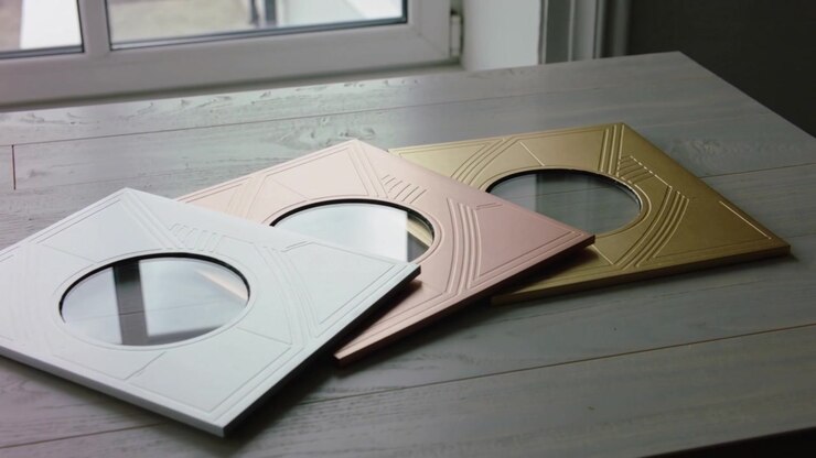 Sliding camera revealing three embossed metal panels on wooden table, to highlight gold panel