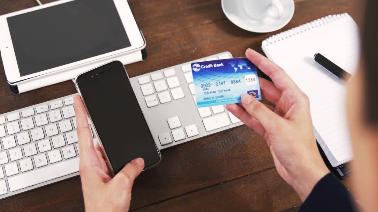Donna d'affari che fa acquisti online con il cellulare e una carta di credito