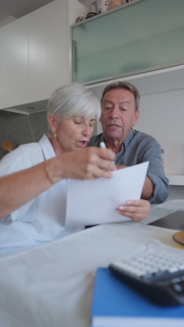 Older couple reviewing paperwork at home