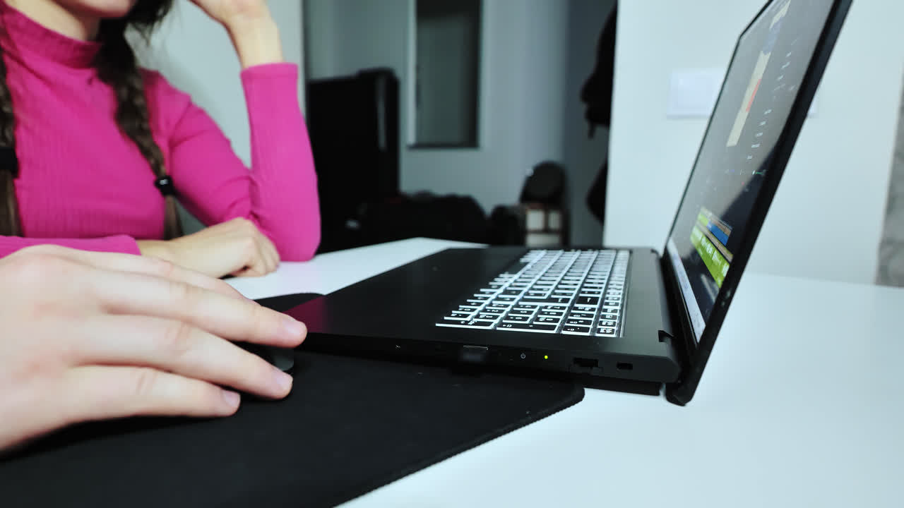 Man demonstrates video editing techniques while woman observes and tries herself