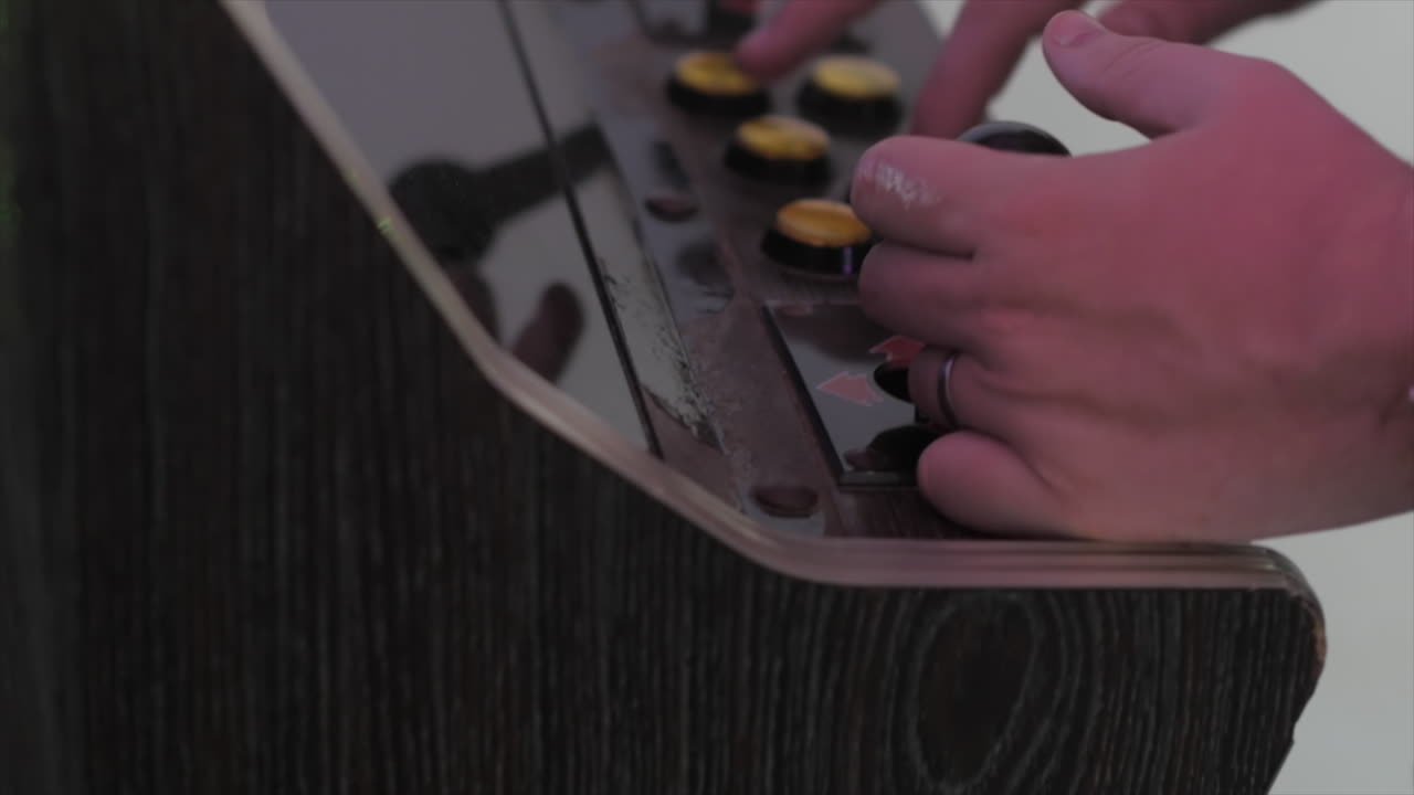 80 년대 아케이드 캐비 비디오 게임 기계에서 연주하는 사람