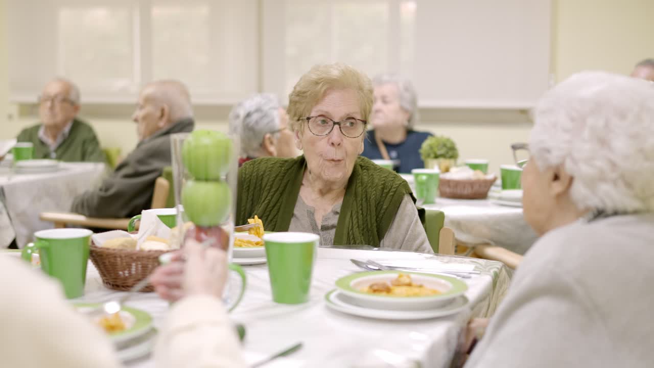Senior woman eating in a dining room of geriatric