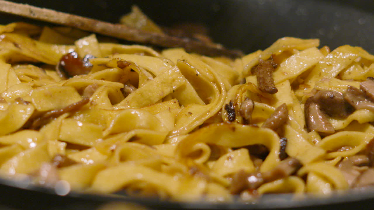 Close Up of Fresh Mushroom Italian Tagliatelle Being Cooked with Various Fungi Including Champignon, Shitake, Nameko. Home Cooked Cream Sauce Based Pasta Dish.