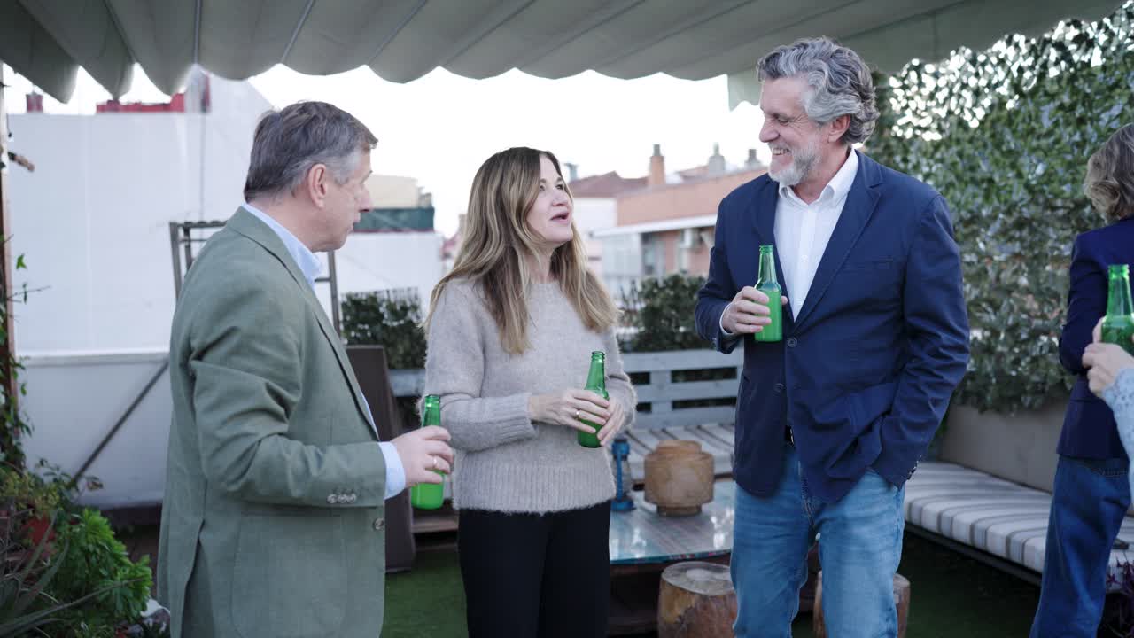 Amigos socializando y conversando en una terraza en la azotea.