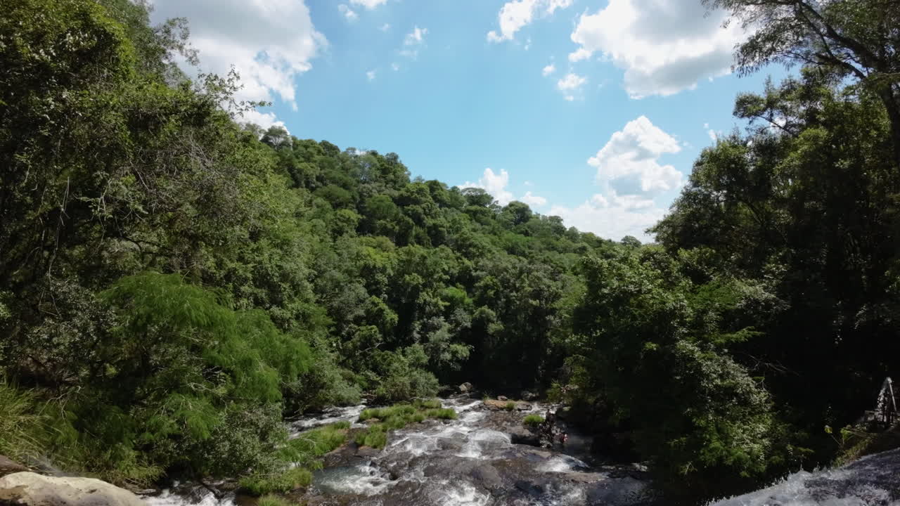 Aerial view of Camping Salto Piedras Blancas waterfall cascading through the lush rainforest of Misiones, Argentina, highlighting the region's vibrant biodiversity and tourist landscape attractions