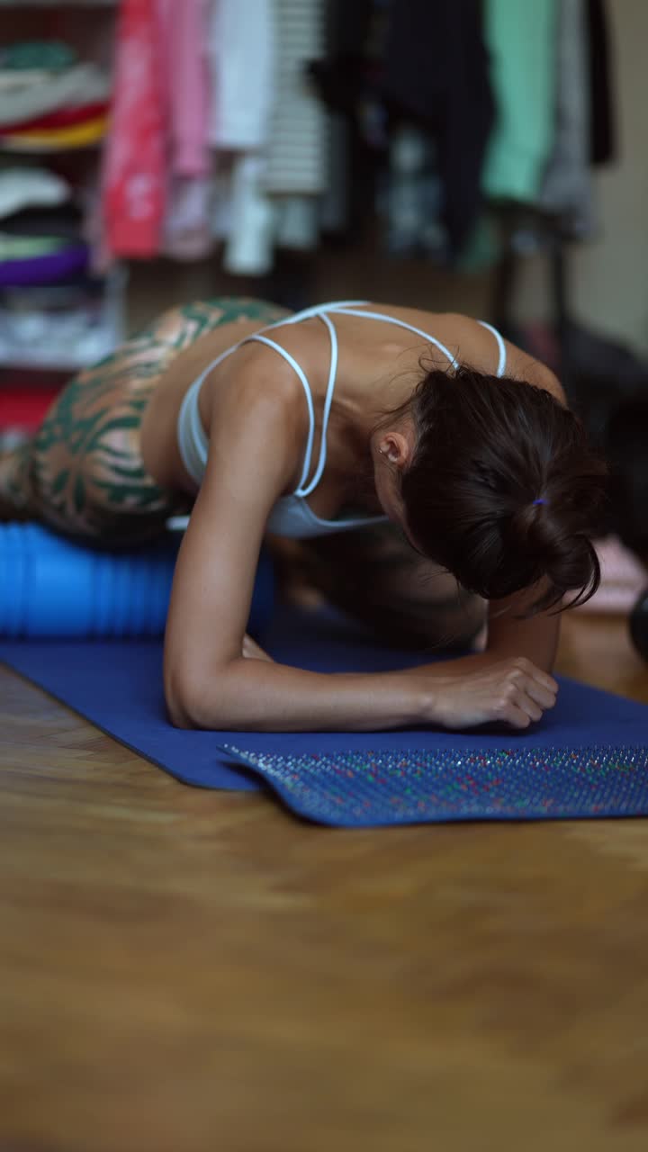 mujer usando un rodillo de espuma para estirarse en casa