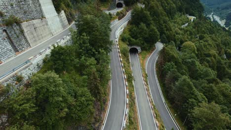 flying above the idyllic mountain serpentine road plöckenpass in italy by the natural austrian alps in summer with green forest trees and cars on the street