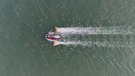 Drone-topdown-shot-of-a-Fishers-boat-dragging-the-nets-thru-the-water