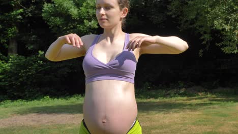 Pregnant-caucasian-woman-stretching-arms-in-the-garden