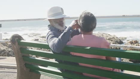 Feliz-Pareja-Afroamericana-Mayor-Sentada-En-Un-Banco-En-El-Paseo-Marítimo,-Cámara-Lenta