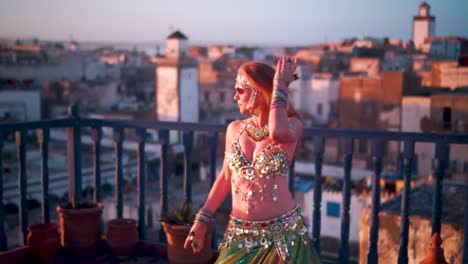 slow motion of beautiful dancer performing on a rooftop at sunset in morocco