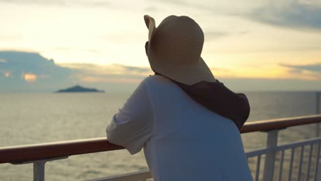 woman wear straw hat enjoying sunset from cruise ship