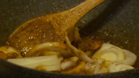 closeup of stirring onions in chilli prawns cooking