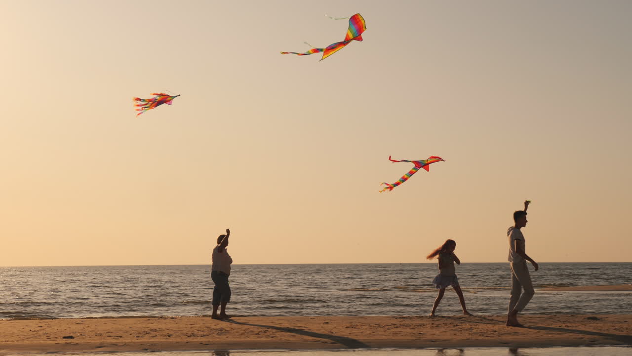 молодая семья активно проводит время вместе - они играют в воздушных змеев