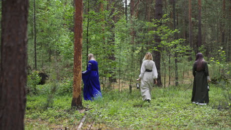 Women-in-middle-age-dresses-with-lanterns-walk-in-forest