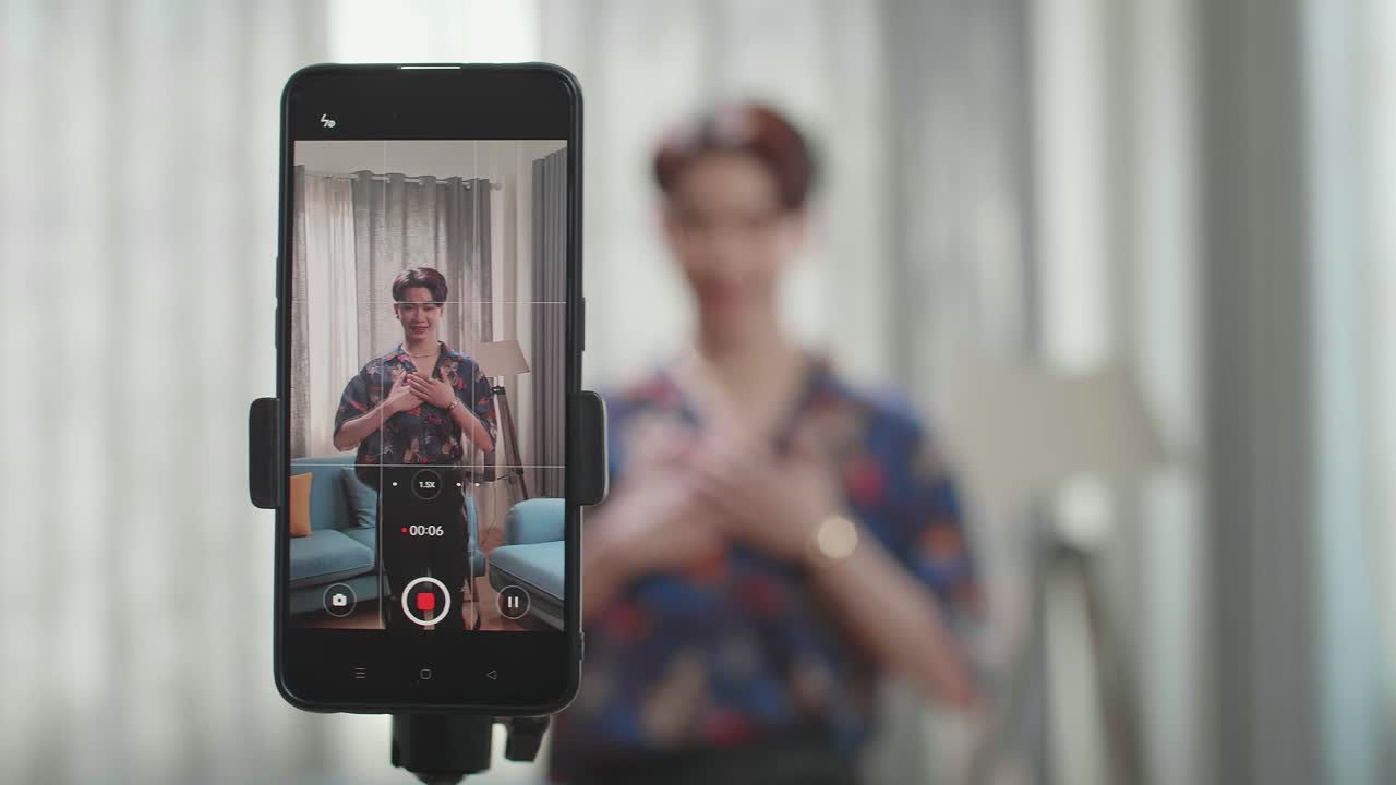 Smartphone di un uomo transgender asiatico che balla mentre gira contenuti video per i social network