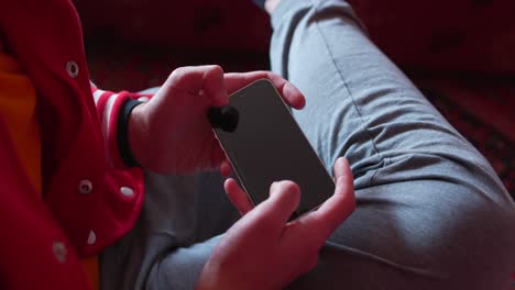 a close-up of a man's hands while he plays a game on his smartphone, providing an intimate view of the gaming experience