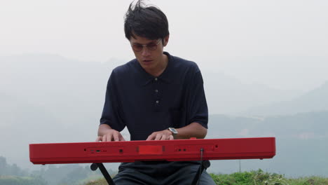 primer plano de un pianista tocando un piano portátil en las tierras altas del sudeste asiático