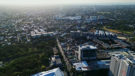 Picturesque-overhead-aerial-view-of-a-stunning-developing-metropolitan-city-with-tall-buildings-and-busy-streets-in-Muntinlupa,-Philippines-during-sunset