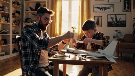 father and son building a model airplane together
