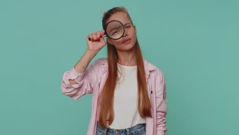 Researcher-scientist-girl-holding-magnifying-glass-near-face,-looking-to-camera-with-big-zoomed-eye