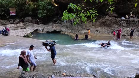 happy tourist slide in front of the bantimurung waterfall