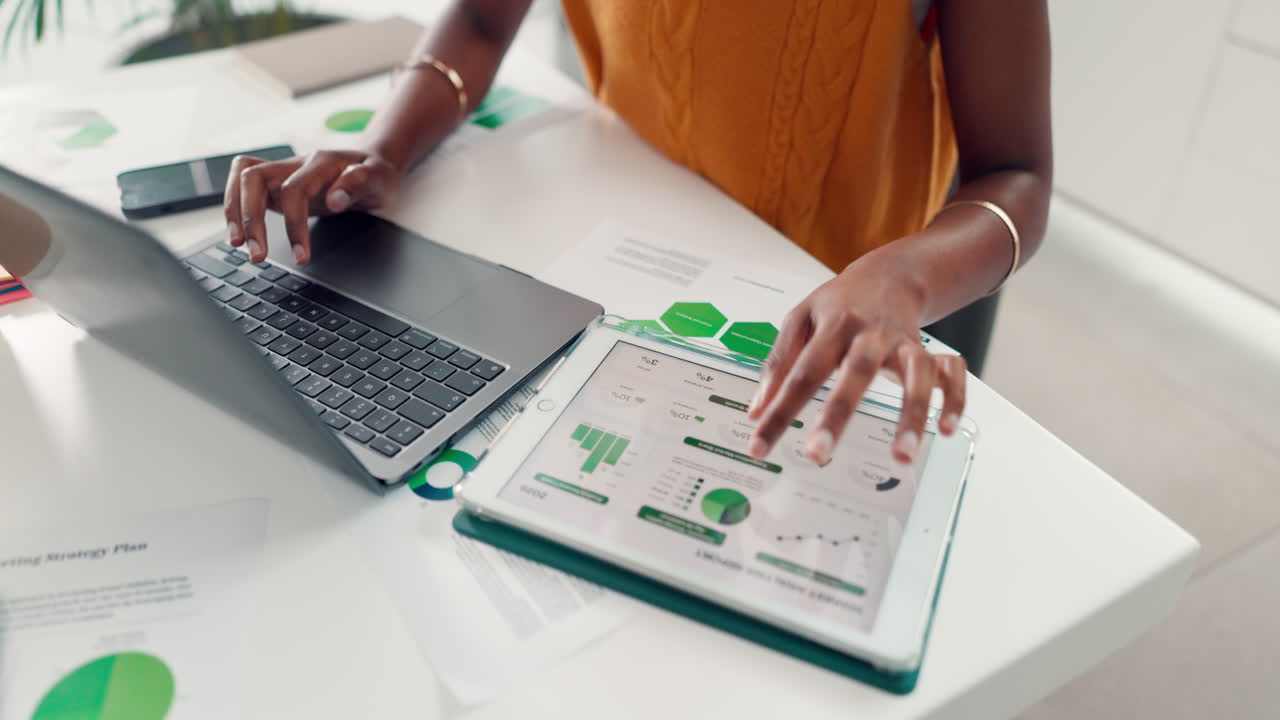 Person Working on Laptop and Tablet with Business Data