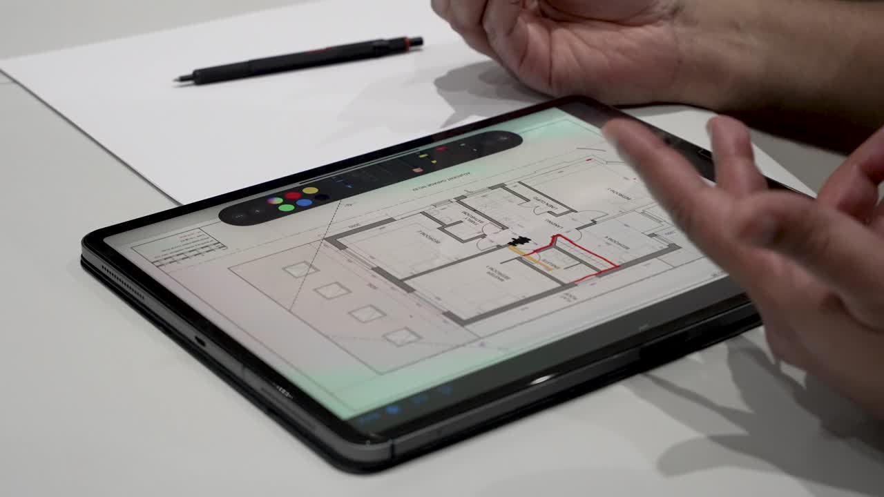 House Engineer erasing some architectural house plans and collaborate using tablet technology. Static shot
