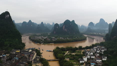 drone disparado inclinando hacia las montañas en yangshuo, sombrío, día nublado en china