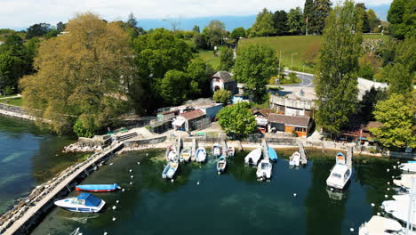 aerial: nyon fishing port during the day in canton of vaud, switzerland, orbit drone shot