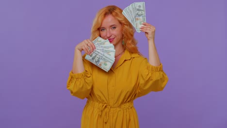 proud arrogant rich stylish girl holding money cash in dollars banknotes, smiling, looking at camera