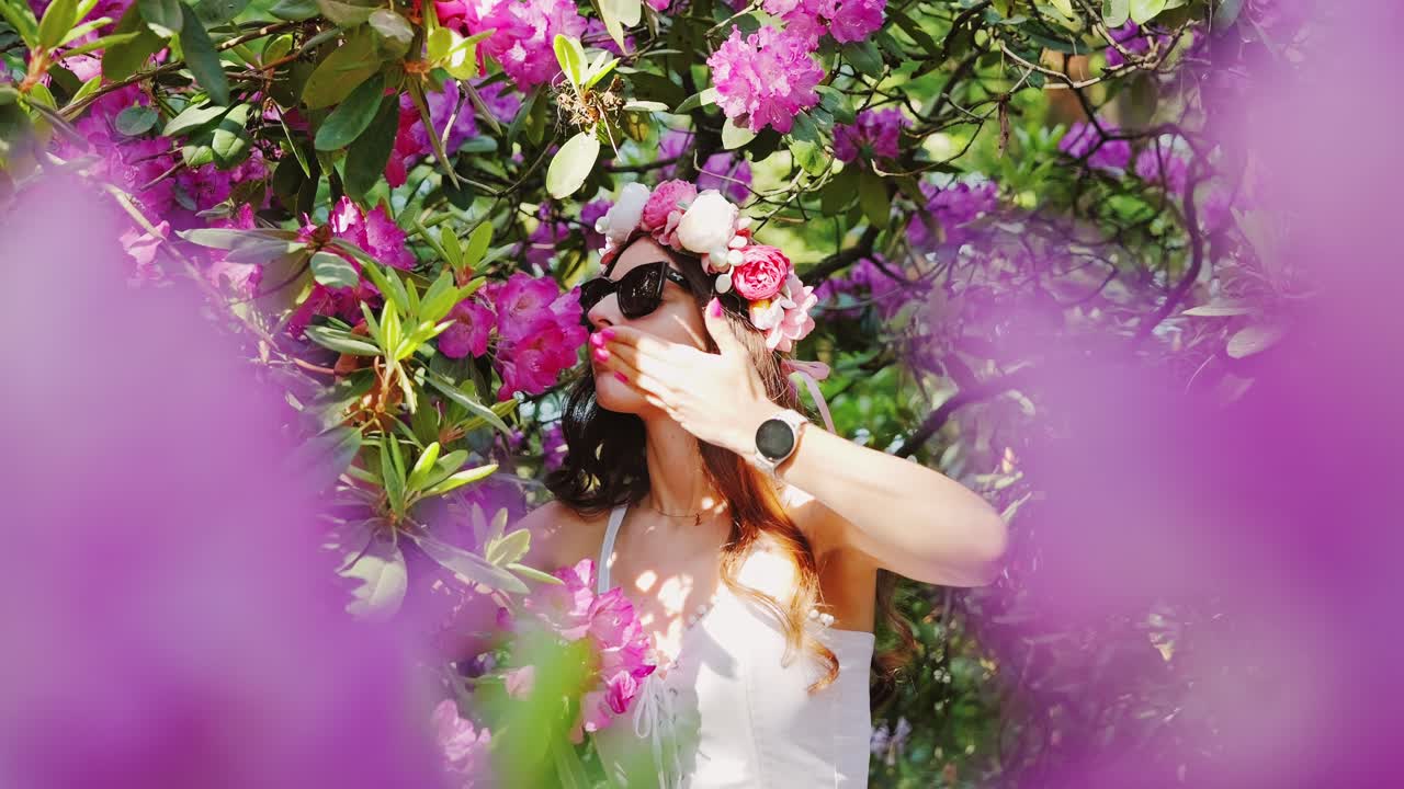 Latvia’s rhododendron garden near Riga, woman gracefully draws in spring aroma