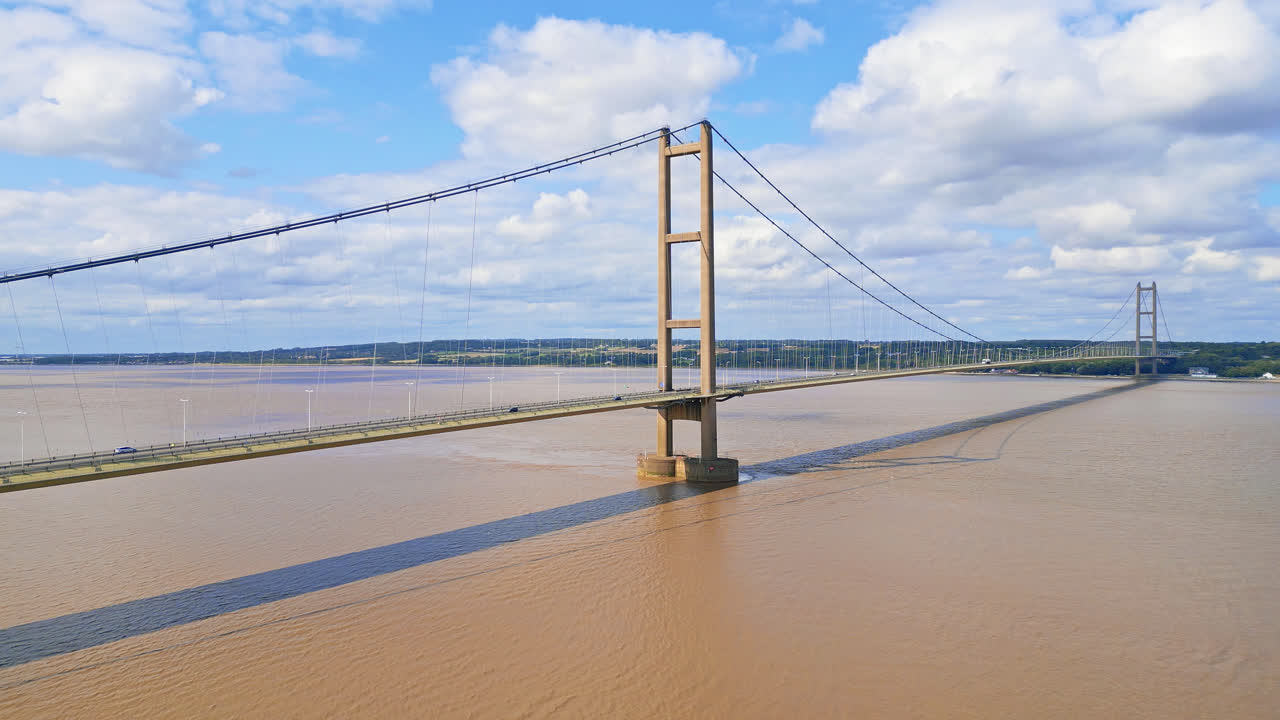 Aerial drone captures Humber Bridge, world's 12th largest suspension span, over River Humber, connecting Lincolnshire to Humberside amid traffic