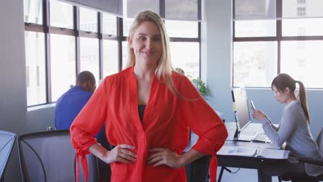 Businesswoman-looking-at-camera-in-modern-office