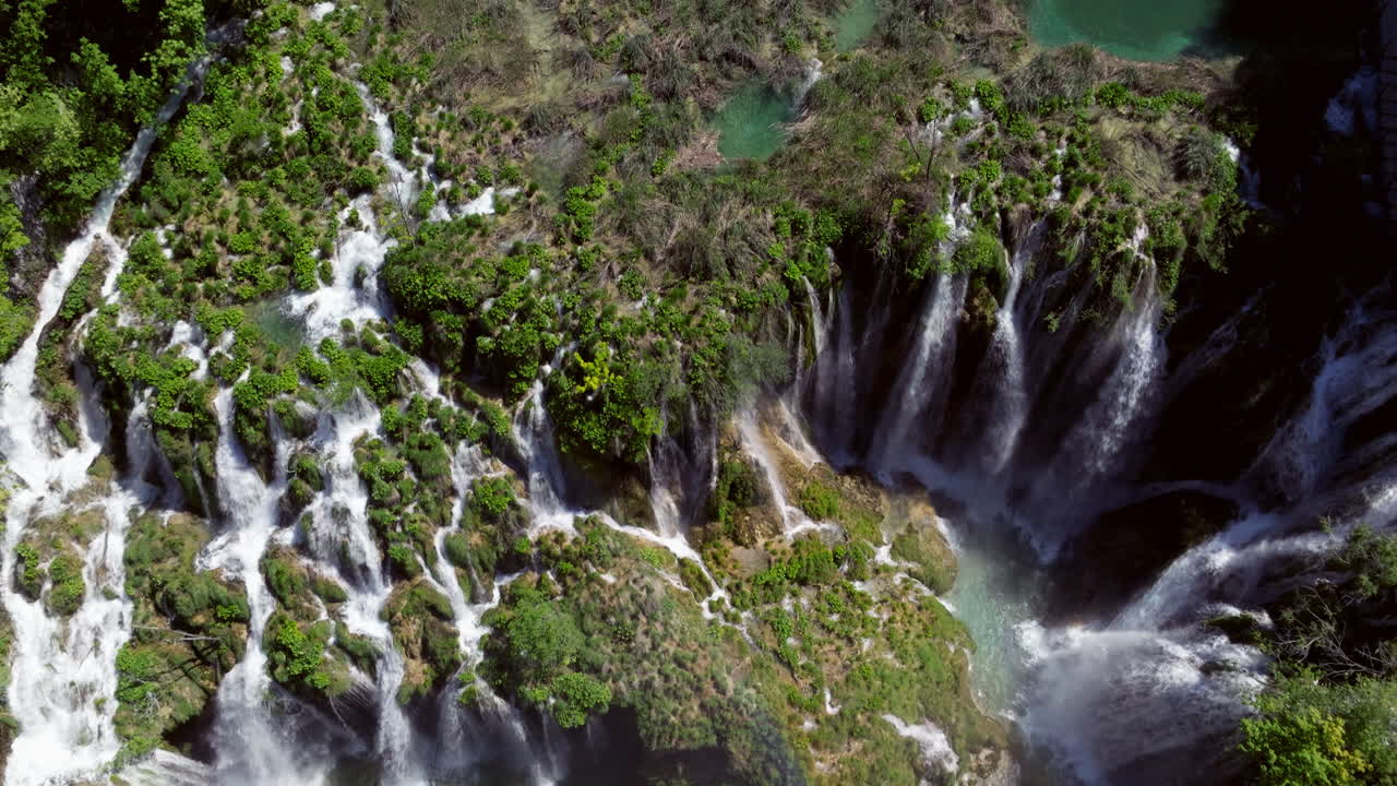 Cascades Of Waterfalls Flowing Over Lush Green Rock Formations At Plitvice Lakes National Park In Karlovac County, Croatia. aerial shot