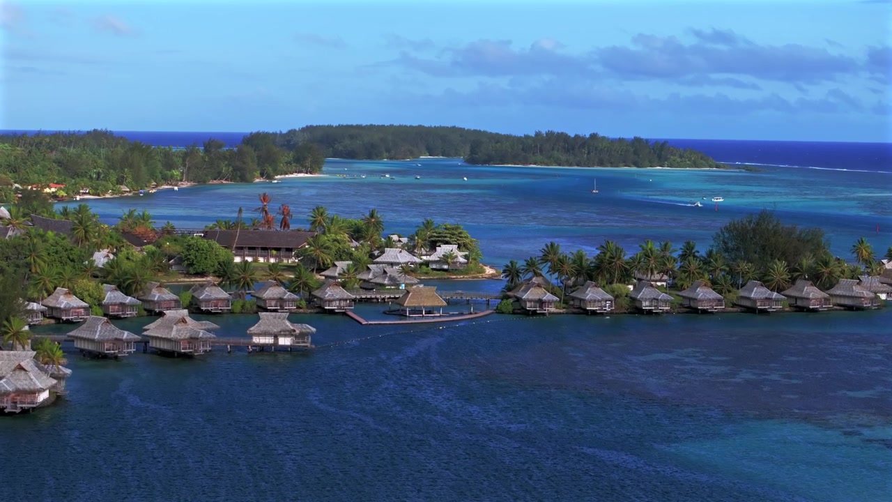 Cook's Bugt Tahiti, Bora Bora bungalows over koralrev, havkanal, Opunohu Bugt, Ta'ahiamanu Offentlige Strand, Moorea Fransk Polynesien. Luftfoto fra drone af sejlbåde og både en solrig eftermiddag med blå himmel, opadgående bevægelse.