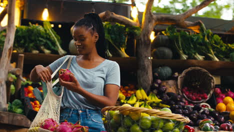 female customer at market stall choosing fresh fruit and vegetables