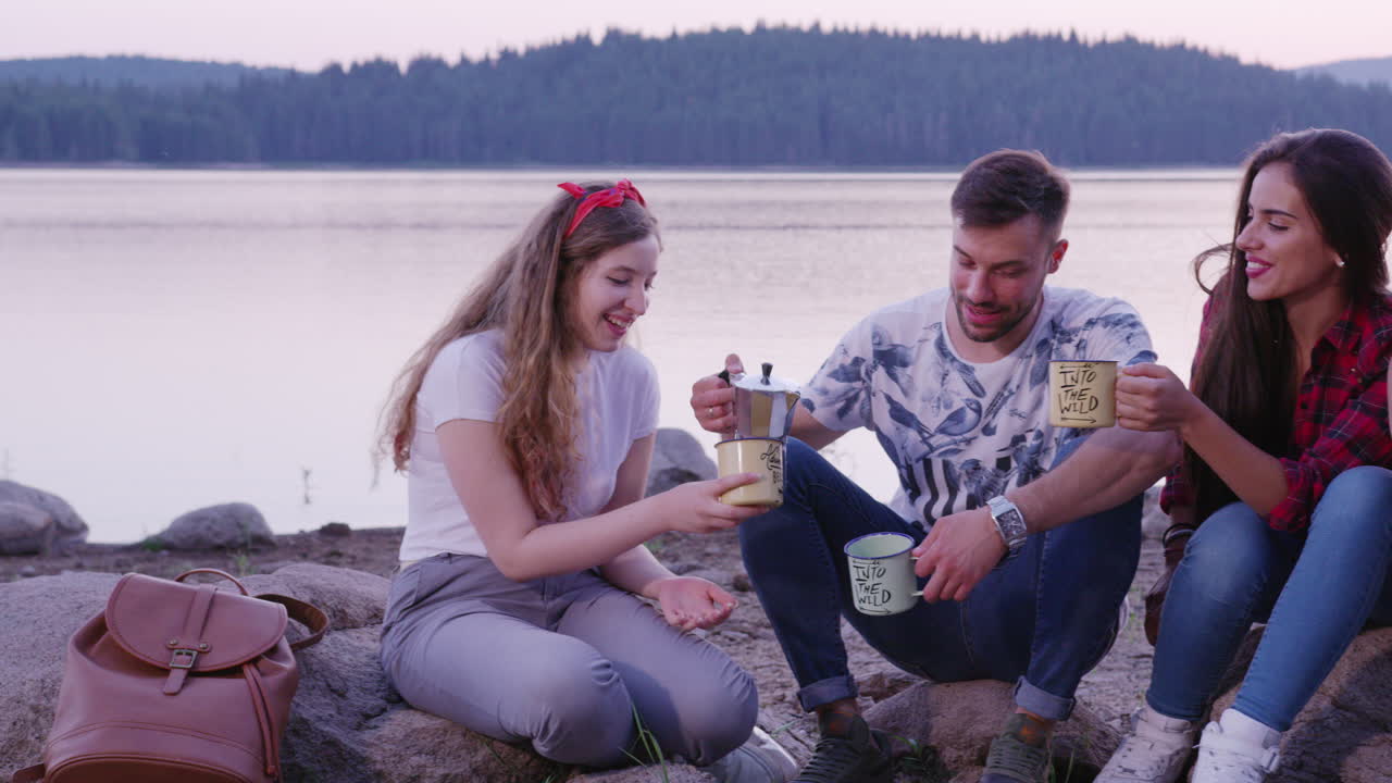 Amici che si godono un caffè al lago