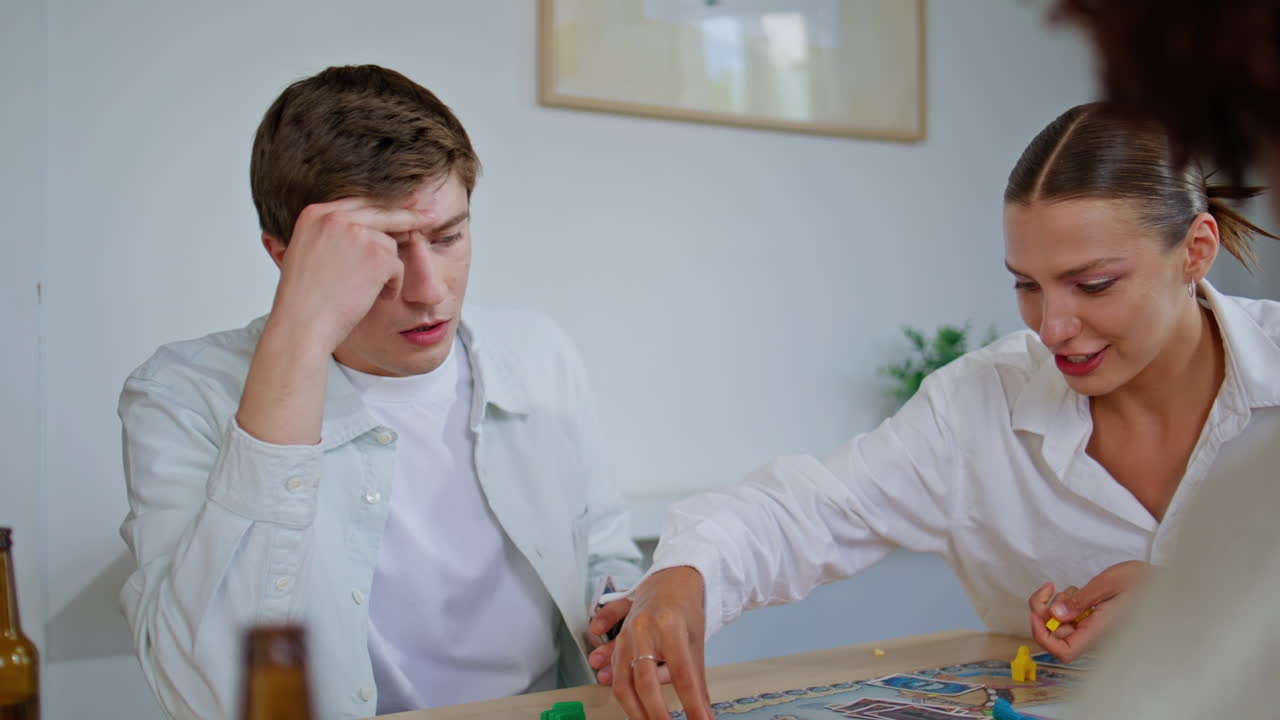 Girl player holding chips playing board game apartment closeup. Students talking