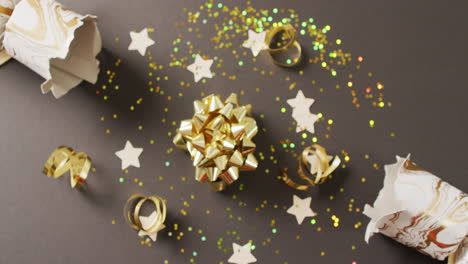 video of christmas crackers, stars and decoration on grey background