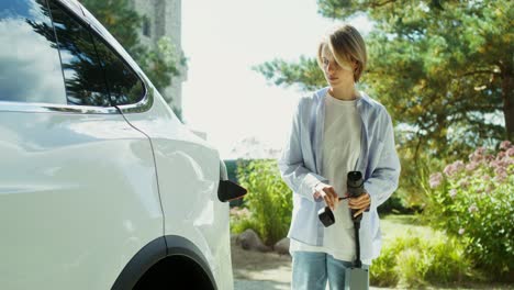 woman charging electric car at home