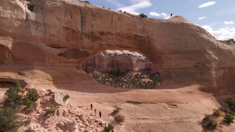 Flying-Towards-The-Hole-Of-Wilson's-Arch-A-Dramatic-Red-tinted-Sandstone-Arch-Overlooking-The-Desert-Landscape-Near-Moab,-Utah,-USA