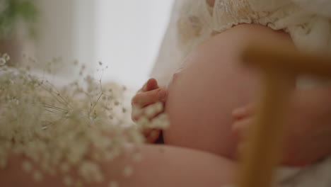 pregnant woman gently caressing her belly close-up
