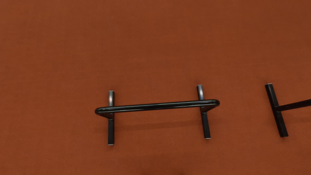 Hands gripping a pull-up bar against a textured orange wall