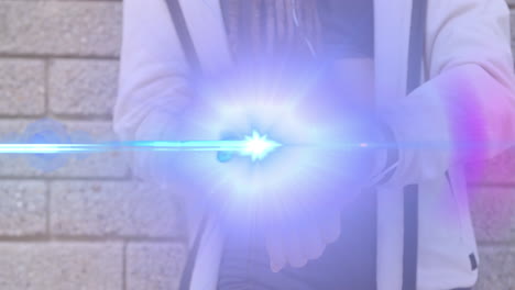 animation of light beam and lens flare over midsection of woman using smartwatch