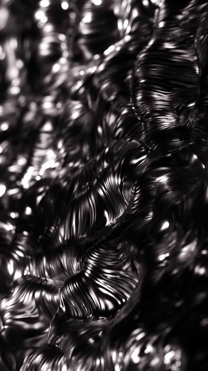 Foto in bianco e nero di oggetti metallici lucidi in un mucchio. Animazione in loop verticale