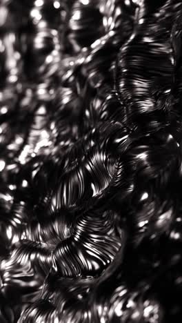 black and white photo of shiny metal objects in pile. vertical looped animation